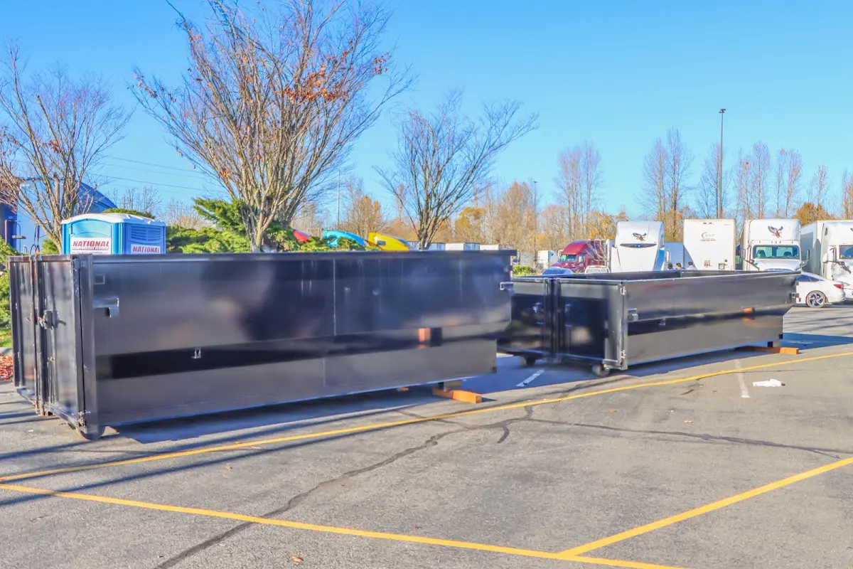 Professional dumpster rental service with roll-off container on residential driveway in Pass Christian